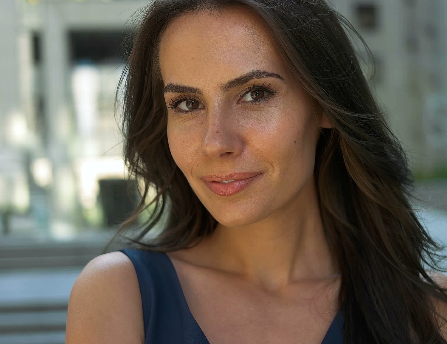 Smiling woman with long hair outdoors.