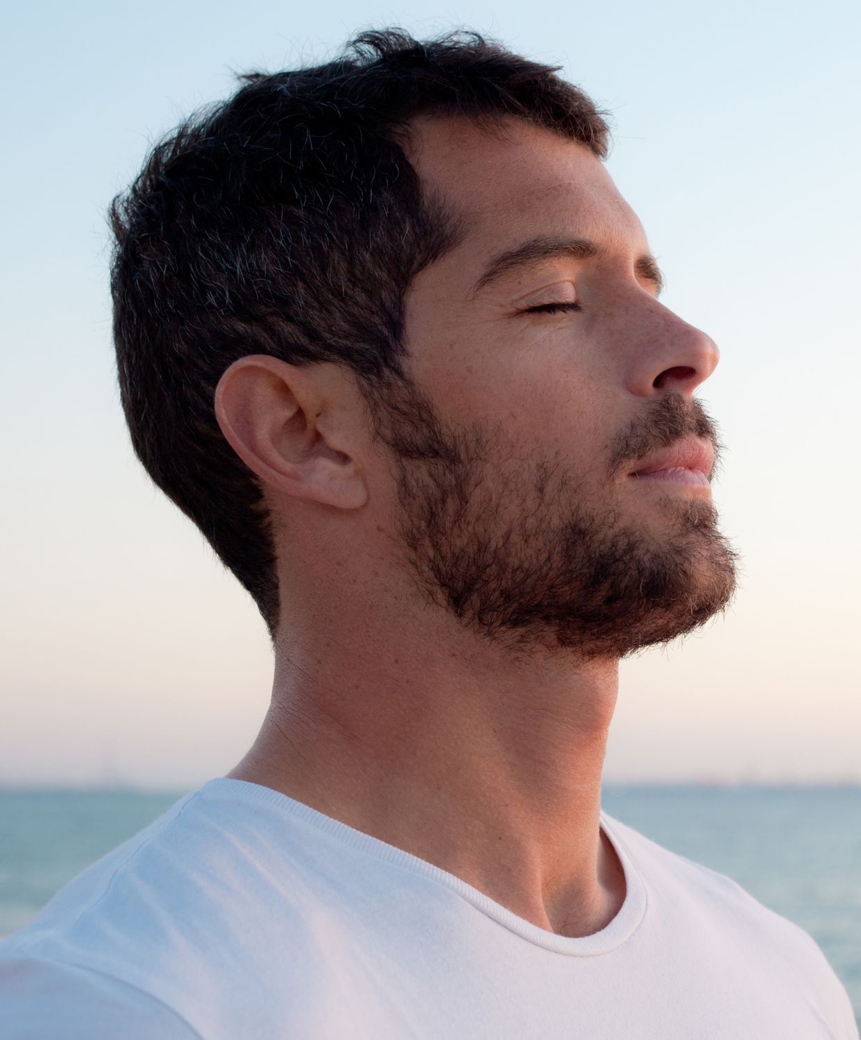 Man with closed eyes by the sea.