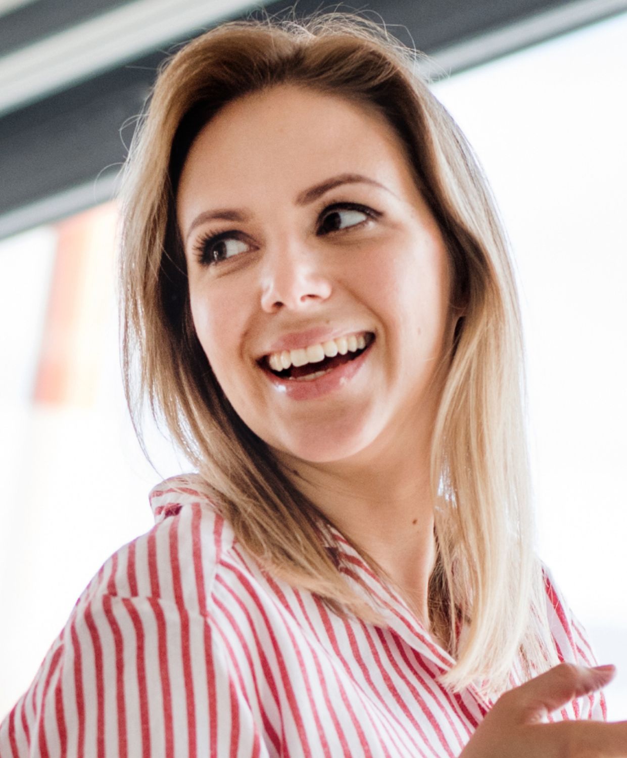 Smiling woman in striped shirt looking happily.
