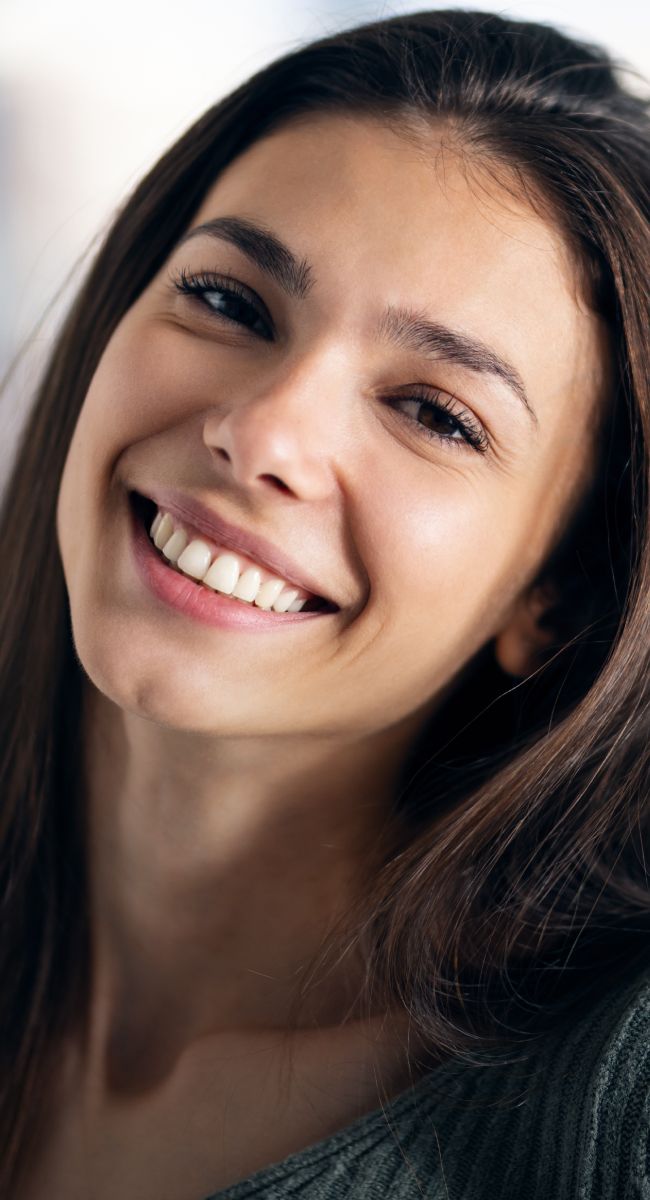 Smiling woman with long brown hair, portrait.