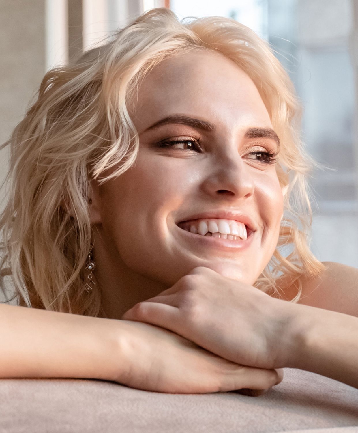 Smiling woman with wavy blonde hair.