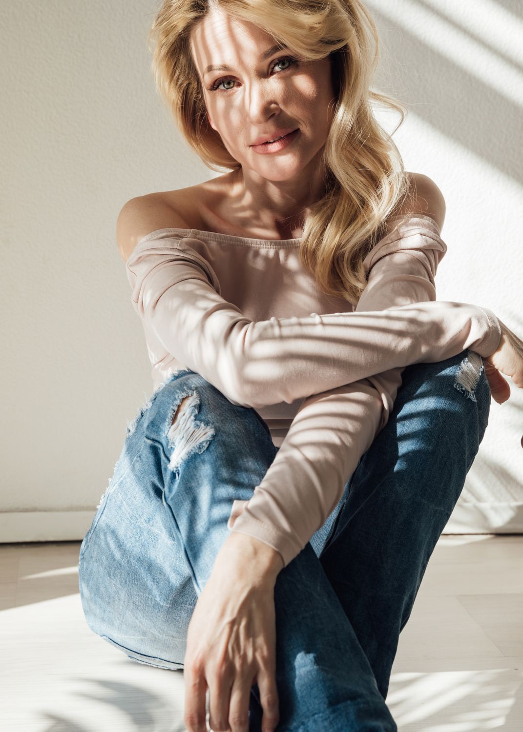 Woman sitting with natural light and shadows.