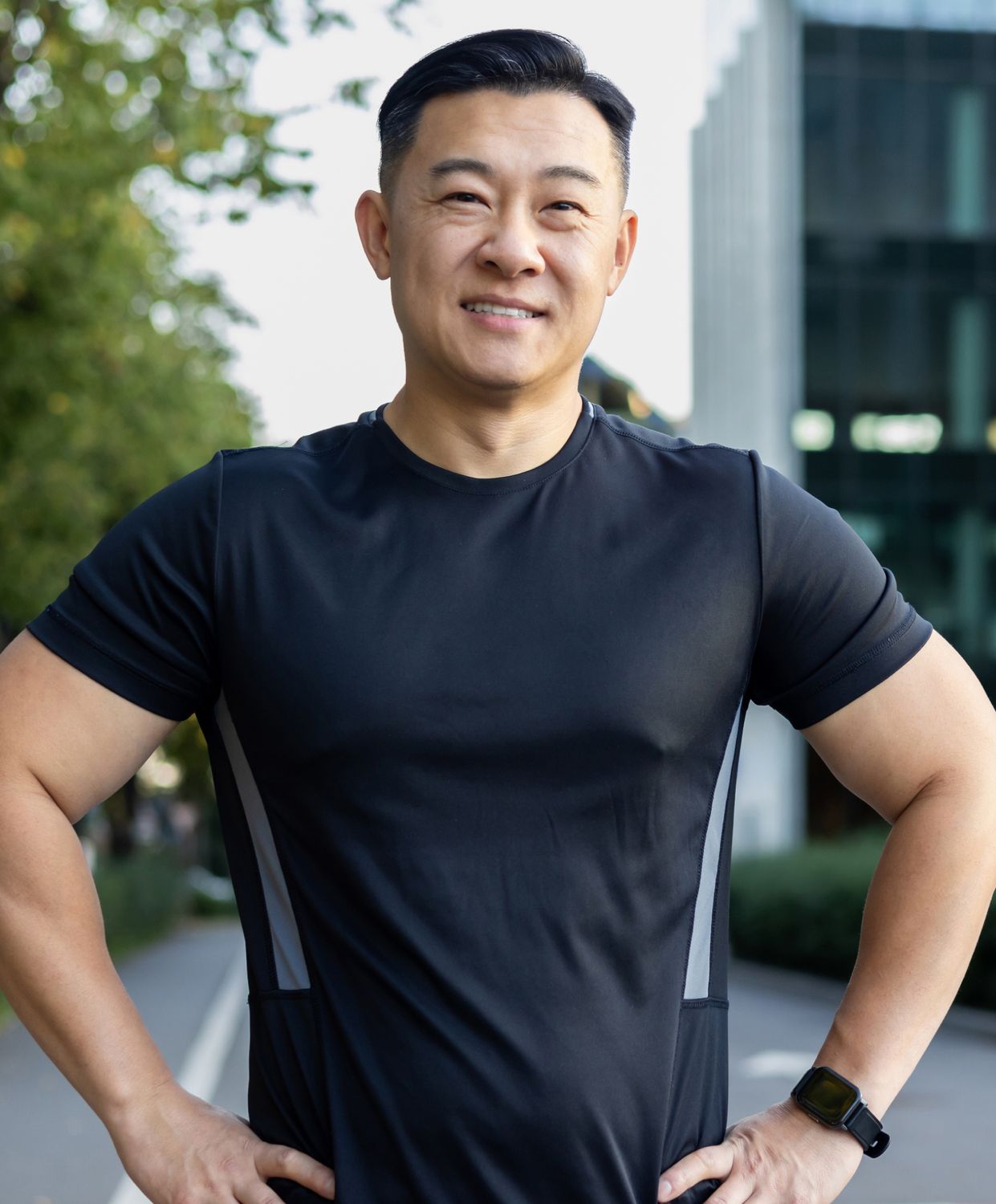 Smiling man wearing a black athletic shirt outdoors.