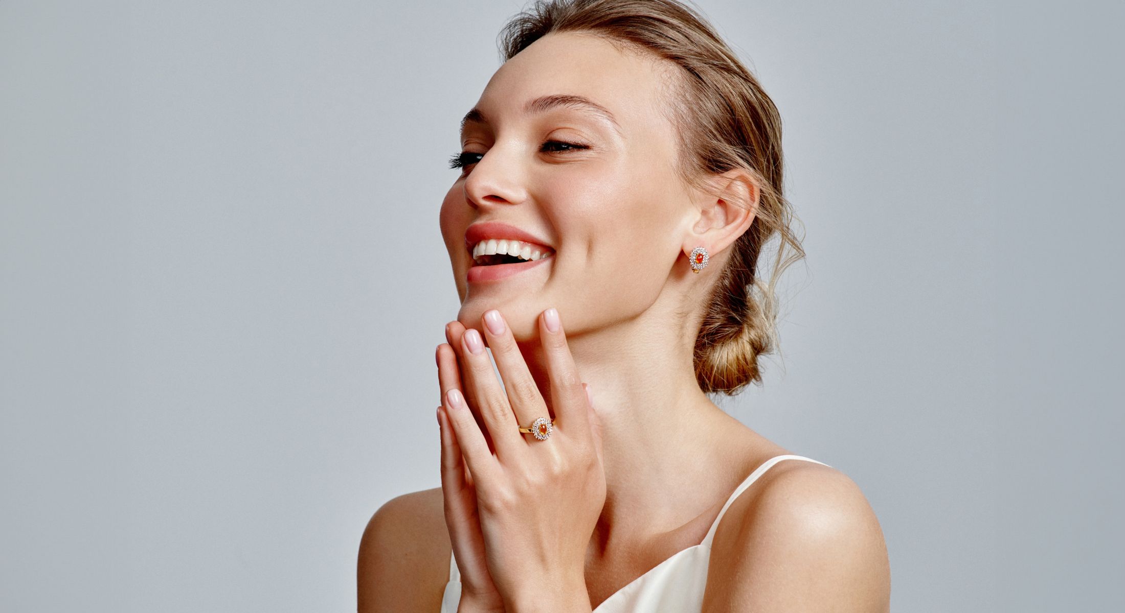 Woman smiling while wearing elegant jewelry.