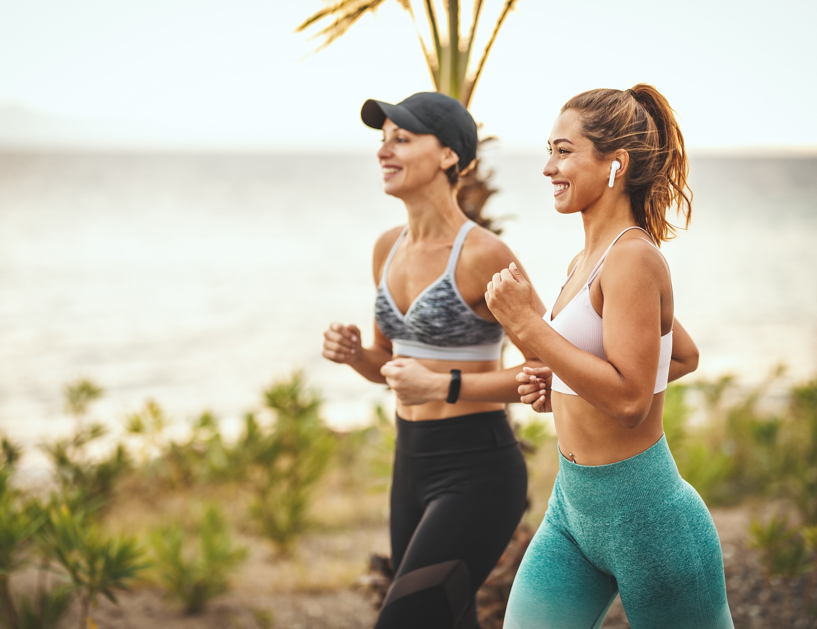 Two women jogging by the beach.