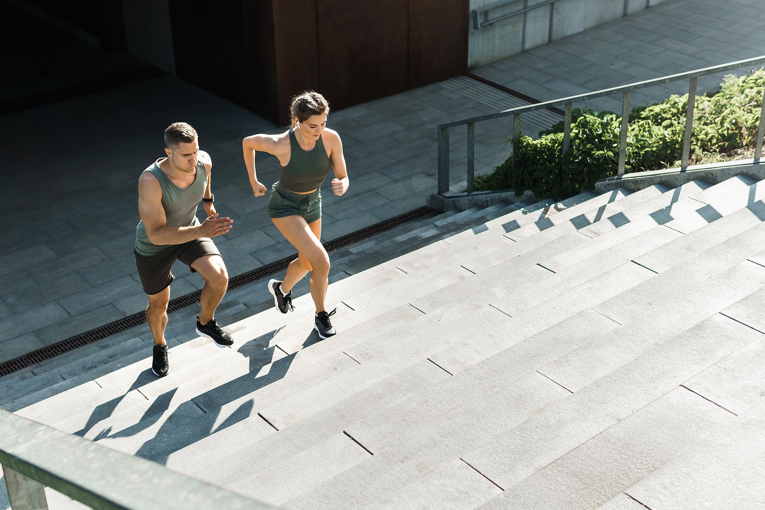 Athletes running up outdoor stairs during workout.